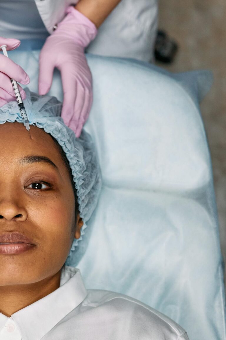 A woman receiving a cosmetic forehead injection in a clinical setting.